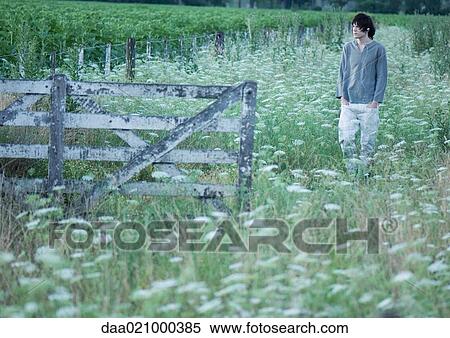 Teenage boy walking in field, listening to earphones View Large Photo Image Stock Photography - Teenage boy walking in field, listening to earphones. Fotosearch