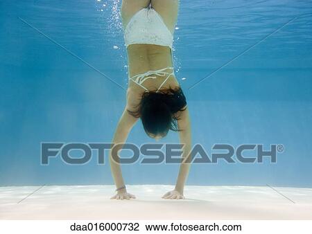Teenage girl doing handstand underwater View Large Photo Image Stock Image - Teenage girl doing handstand underwater. Fotosearch