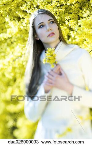 Teenage girl holding flowers, looking up, selective focus View Large Photo Image Stock Image - Teenage girl holding flowers, looking up, selective focus. Fotosearch