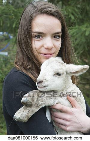 Teenage girl holding lamb View Large Photo Image Stock Photograph - Teenage girl holding lamb. Fotosearch