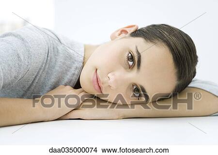 Teenage girl resting head on arms, smiling at camera View Large Photo Image Picture - Teenage girl resting head on arms, smiling at camera. Fotosearch