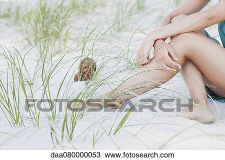 Teenage girl sitting on beach, low section View Large Photo Image Stock Image - Teenage girl sitting on beach, low section. Fotosearch