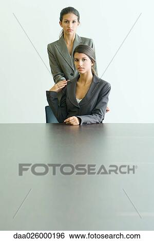 Teenage girl standing behind twin sister, hands on shoulders, both dressed in suits and looking at camera View Large Photo Image Stock Photograph - Teenage girl standing behind twin sister, hands on shoulders, both dressed in suits and looking at camera. Fotosearch