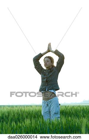 Teenage girl standing in yoga pose in field, eyes closed View Large Photo Image Picture - Teenage girl standing in yoga pose in field, eyes closed. Fotosearch