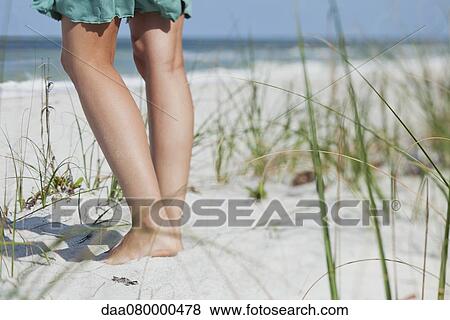 Teenage girl standing on beach, low section View Large Photo Image Stock Photo - Teenage girl standing on beach, low section. Fotosearch