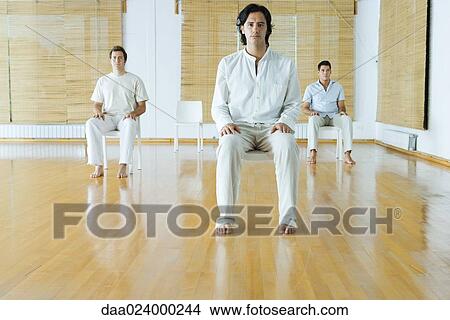 Three adult men sitting in chairs in wellness center, facing camera View Large Photo Image Picture - Three adult men sitting in chairs in wellness center, facing camera. Fotosearch