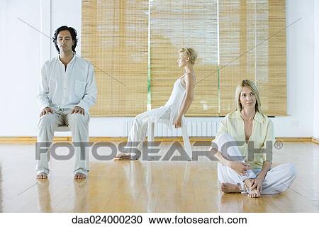 Three adults in various postures in wellness center View Large Photo Image Stock Image - Three adults in various postures in wellness center. Fotosearch