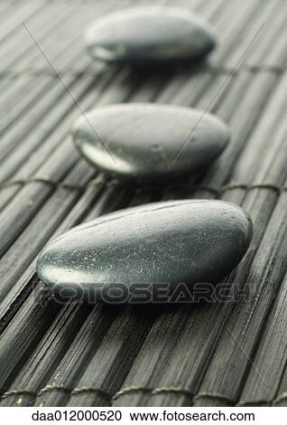 Stock Image - Three smooth black stones. Fotosearch