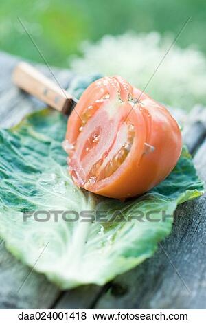 Stock Photo - Tomato being sliced, still life. Fotosearch
