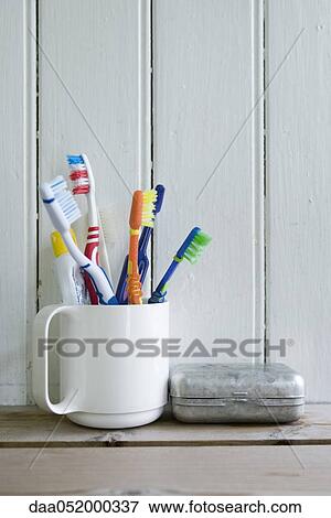 Toothbrushes in mug on shelf View Large Photo Image Stock Photo - Toothbrushes in mug on shelf. Fotosearch