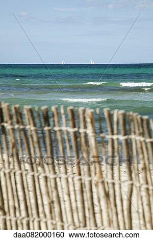 Tranquil beach scene with bamboo fence in foreground View Large Photo Image Stock Image - Tranquil beach scene with bamboo fence in foreground. Fotosearch