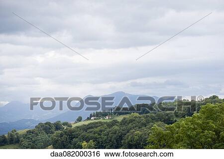 Stock Photograph - Tranquil countryside with mountains visible in the distance. Fotosearch