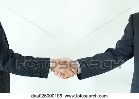 Stock Photography - Two businessmen shaking hands, cropped side view. Fotosearch