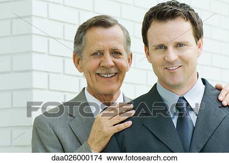 Two businessmen smiling at camera, portrait View Large Photo Image Picture - Two businessmen smiling at camera, portrait. Fotosearch