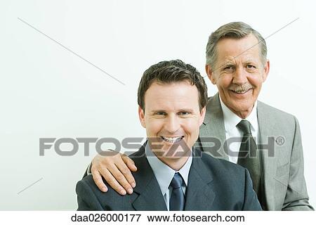 Two businessmen smiling at camera, portrait View Large Photo Image Stock Photo - Two businessmen smiling at camera, portrait. Fotosearch