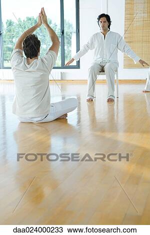Two men sitting in serene positions in wellness center View Large Photo Image Stock Image - Two men sitting in serene positions in wellness center. Fotosearch