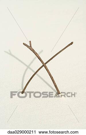 Two sticks making an x mark in sand, close-up View Large Photo Image Stock Image - Two sticks making an x mark in sand, close-up. Fotosearch