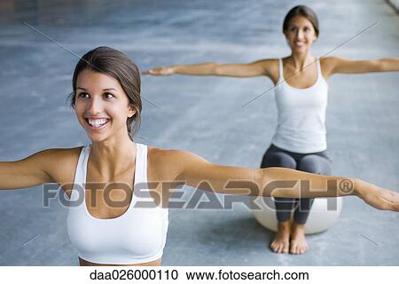 Two teenage girls sitting on fitness balls with arms out, both smiling View Large Photo Image Stock Image - Two teenage girls sitting on fitness balls with arms out, both smiling. Fotosearch