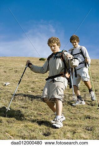 Stock Image - Two young men hiking down mountain. Fotosearch