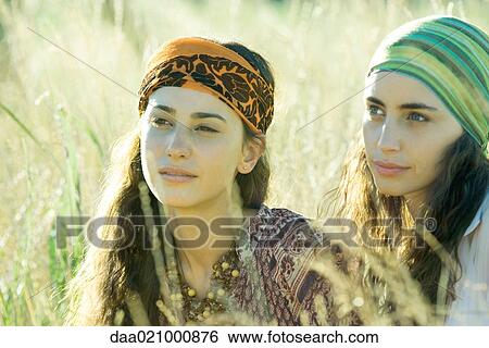 Stock Photograph - Two young women sitting in field. Fotosearch