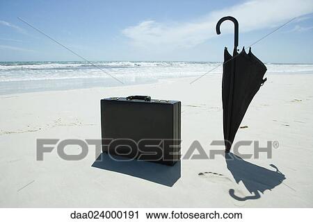 Umbrella and briefcase on beach View Large Photo Image Stock Image - Umbrella and briefcase on beach. Fotosearch