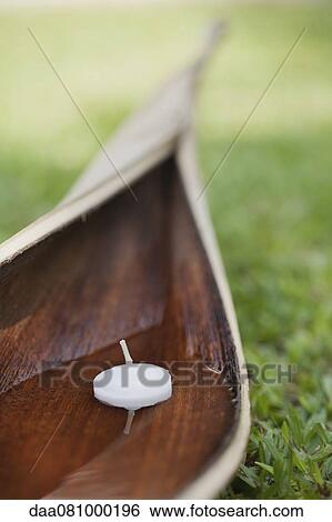Votive candle floating in water cupped within palm leaf View Large Photo Image Stock Photograph - Votive candle floating in water cupped within palm leaf. Fotosearch