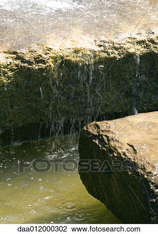 Water flowing over edge of stone block View Large Photo Image Stock Image - Water flowing over edge of stone block. Fotosearch