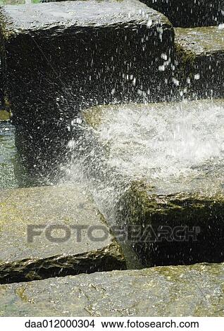 Picture - Water splashing onto stone block. Fotosearch