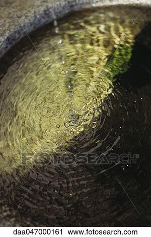 Stock Image - Water trickling into basin, close-up. Fotosearch