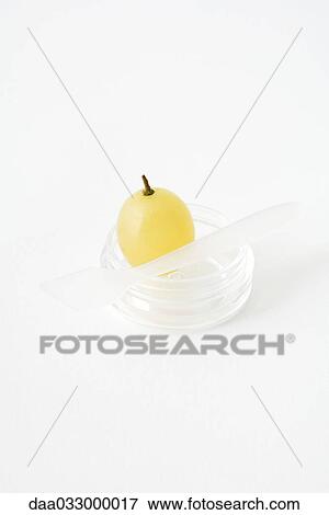 Stock Photo - White grape in small plastic container, close-up. Fotosearch
