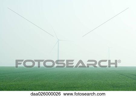 Stock Photograph - Wind turbines in foggy landscape. Fotosearch