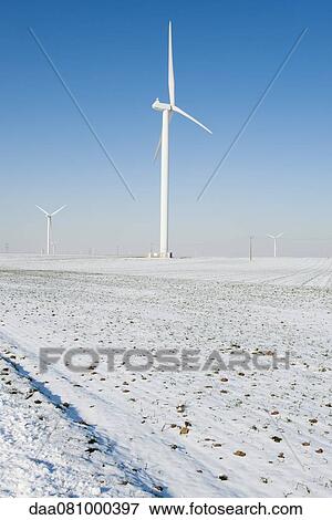 Wind turbines in snow-covered field View Large Photo Image Stock Photo - Wind turbines in snow-covered field. Fotosearch