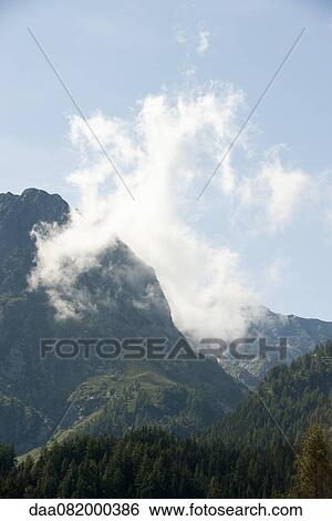 Wispy cloud over mountain landscape View Large Photo Image Stock Photograph - Wispy cloud over mountain landscape. Fotosearch