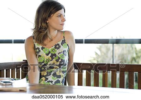 Woman alone at table contemplatively looking away View Large Photo Image Stock Photography - Woman alone at table contemplatively looking away. Fotosearch