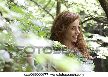 Stock Photo - Woman amongst foliage, portrait. Fotosearch