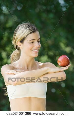 Woman balancing apple on back of hand View Large Photo Image Stock Photograph - Woman balancing apple on back of hand. Fotosearch
