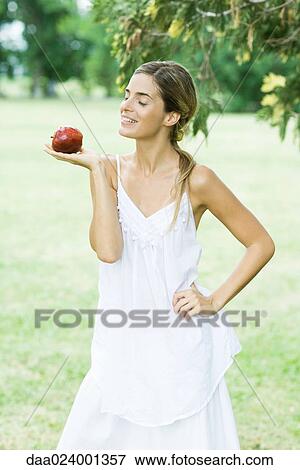 Woman balancing apple on palm of hand, smiling View Large Photo Image Stock Photo - Woman balancing apple on palm of hand, smiling. Fotosearch