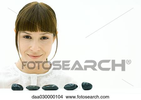 Woman behind row of stones, smiling at camera View Large Photo Image Picture - Woman behind row of stones, smiling at camera. Fotosearch