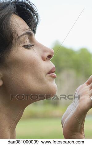 Stock Photo - Woman blowing a kiss, profile. Fotosearch