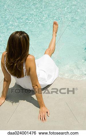 Woman dangling leg into pool, rear view View Large Photo Image Stock Photograph - Woman dangling leg into pool, rear view. Fotosearch