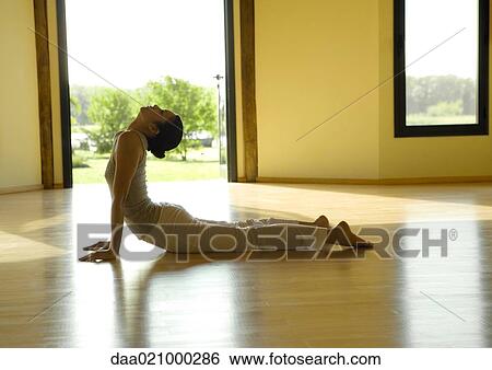 Stock Photograph - Woman doing cobra pose, side view. Fotosearch