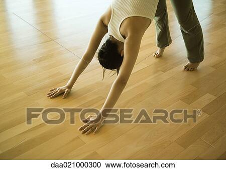 Stock Image - Woman doing downward dog pose. Fotosearch