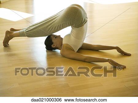 Stock Photograph - Woman doing plow pose. Fotosearch