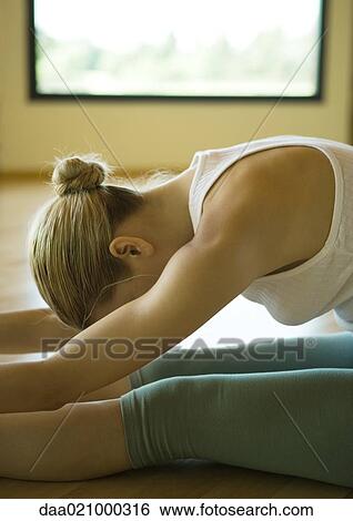 Woman doing seated forward bend View Large Photo Image Stock Photograph - Woman doing seated forward bend. Fotosearch