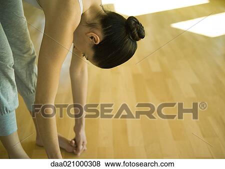 Woman doing standing forward bend, partial view View Large Photo Image Stock Photo - Woman doing standing forward bend, partial view. Fotosearch