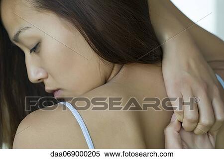 Stock Photography - Woman doing yoga cow face pose, over the shoulder view. Fotosearch