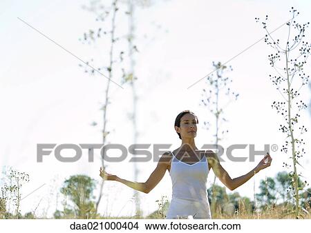 Woman doing yoga pose in field View Large Photo Image Picture - Woman doing yoga pose in field. Fotosearch