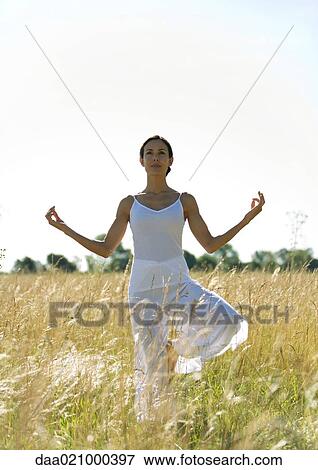 Woman doing yoga pose in field View Large Photo Image Stock Photo - Woman doing yoga pose in field. Fotosearch