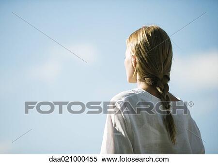 Stock Photography - Woman facing sky, rear view. Fotosearch