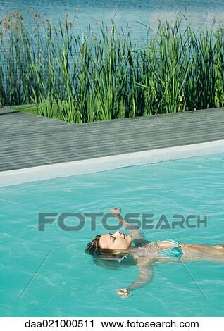 Woman floating on back in pool, waist up View Large Photo Image Stock Image - Woman floating on back in pool, waist up. Fotosearch
